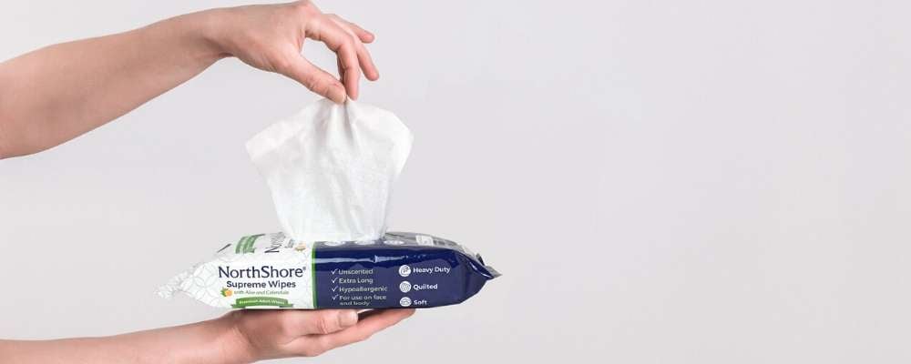 hand pulling out NorthShore adult wipe from packaging