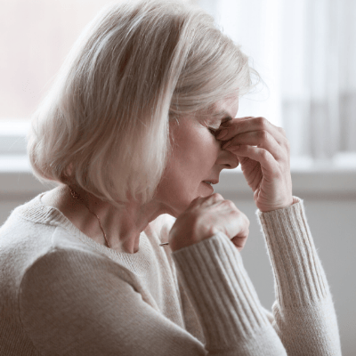 tired senior female caregiver with eyes closes