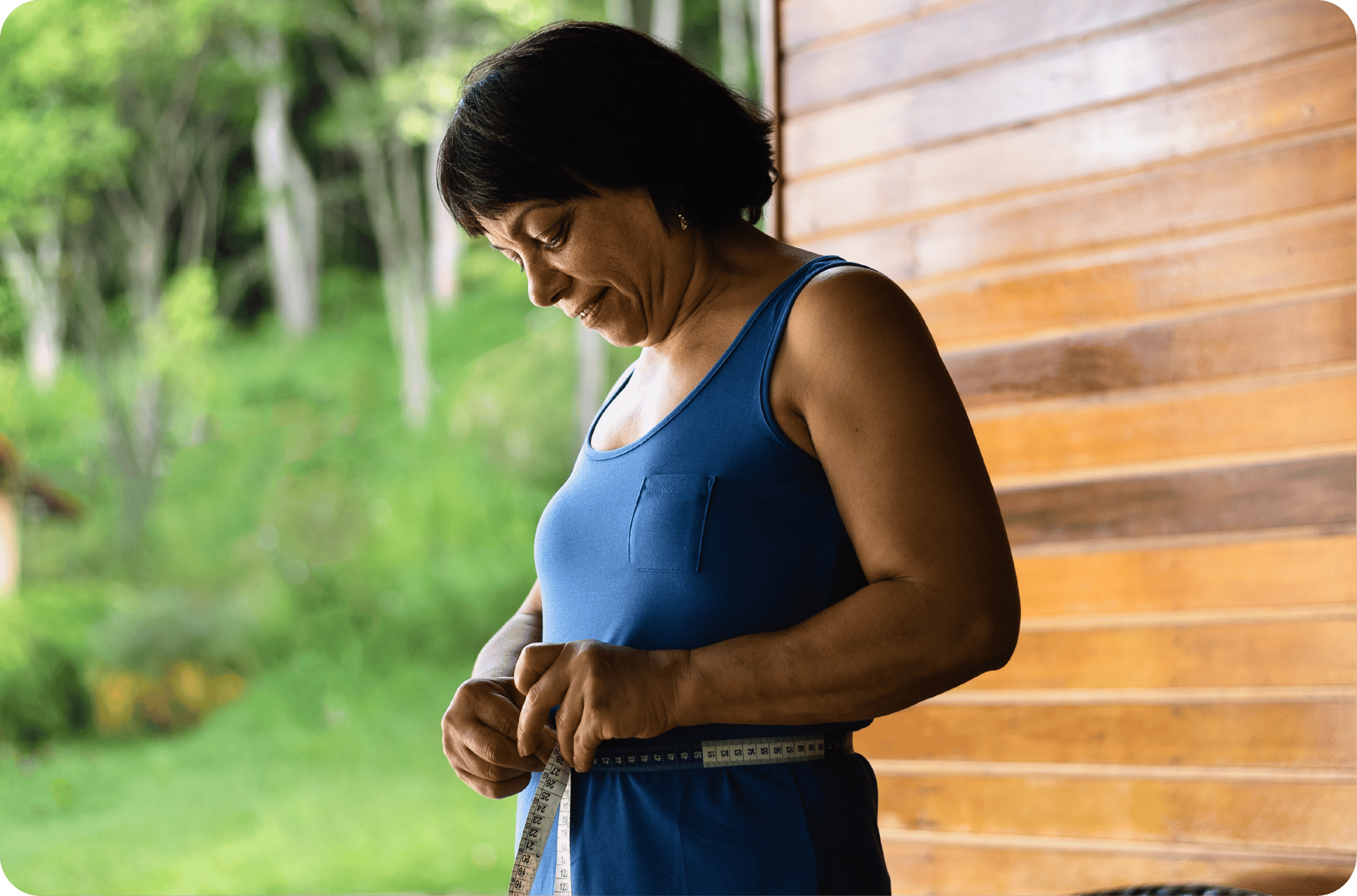 Woman with a tape measure measuring her waist