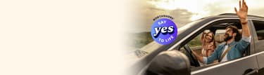 Smiling couple enjoying a drive in an SUV with the NorthShore “Say Yes to Life” logo.