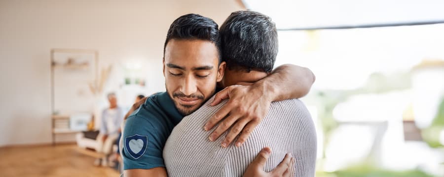 Man embracing another man in a supportive hug, symbolizing compassionate care, trust, and what makes NorthShore unique