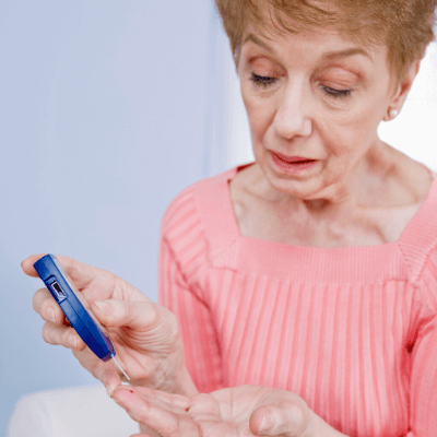 woman performing a blood sugar test at home