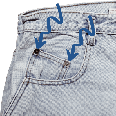 two blue arrows pointing to rivets on jeans