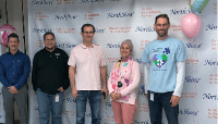 NorthShore managers at pie throwing event in warehouse breakroom