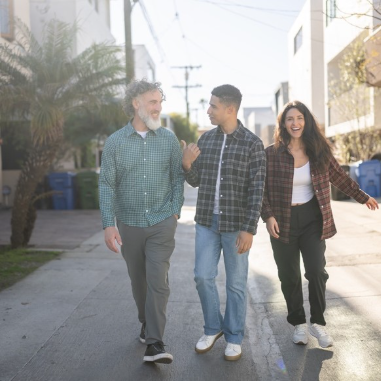 A group of people walking on a sidewalk