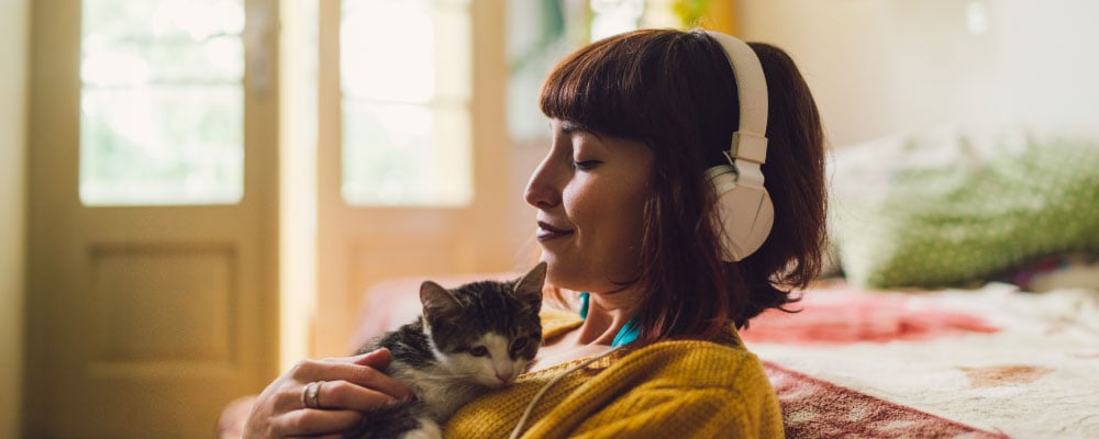 person with headphones and kitten