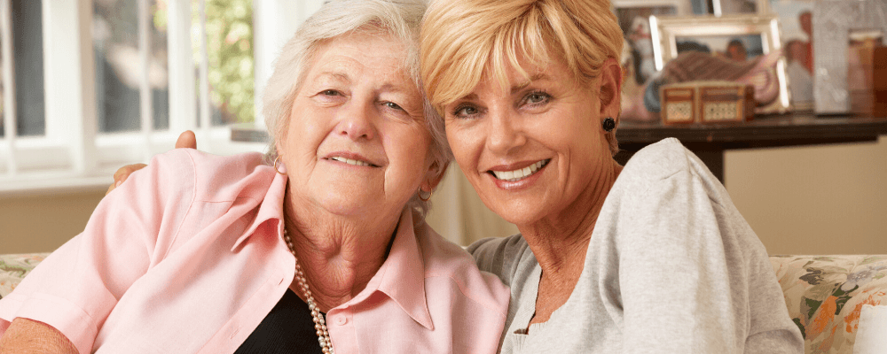 woman and senior mother at home hugging
