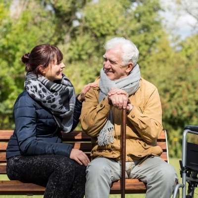 young woman sitting next to elderly man