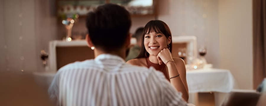 Smiling woman enjoying a date at a restaurant, representing confidence and connection while navigating incontinence