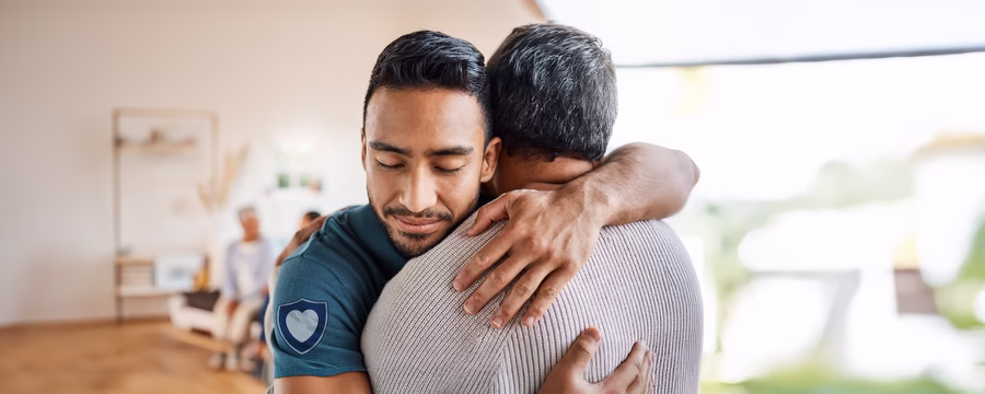 Man embracing another man in a supportive hug, symbolizing compassionate care, trust, and what makes NorthShore unique